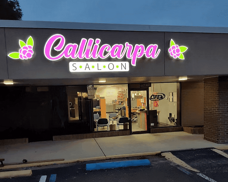 Callicarpa Salon exterior, neon sign lit, accessible parking in front.